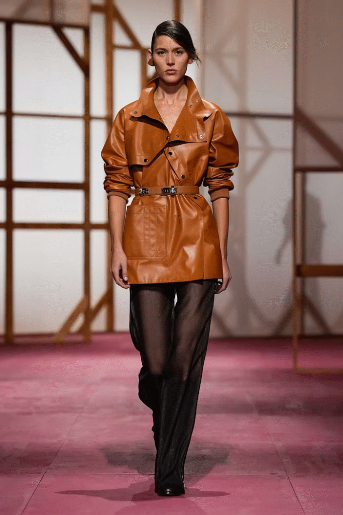 Female model walking the runway in a Hermès outfit