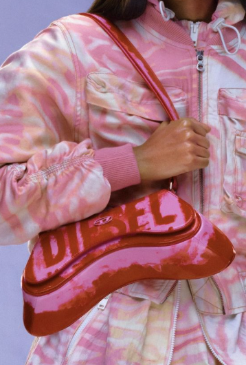 Pink Diesel handbag with a unique curved shape, paired with a pink-and-white tie-dye effect jacket.