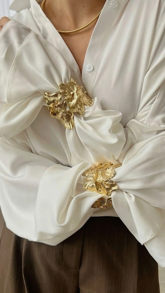 gold cuff bracelets and cream shirt